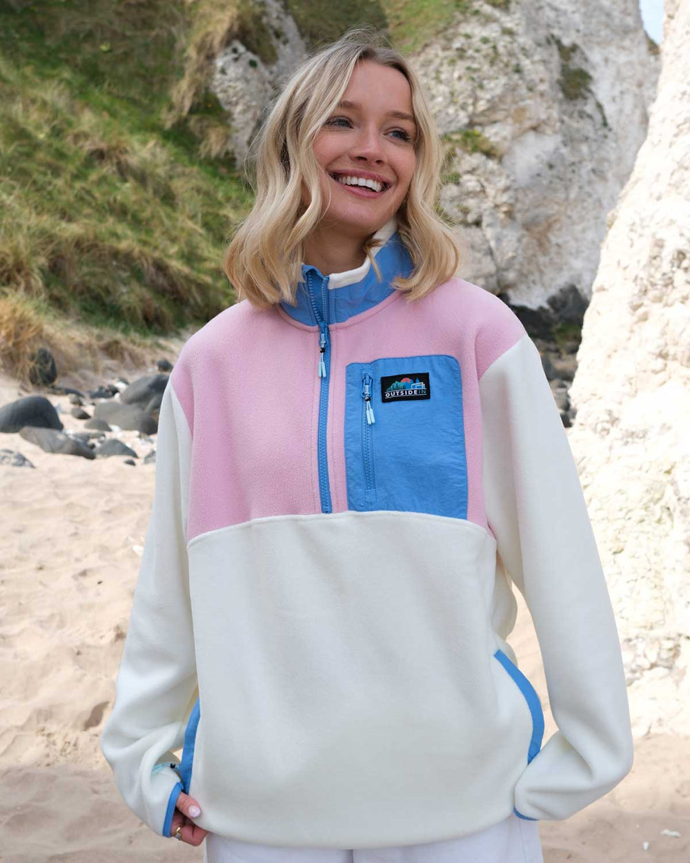 Model wearing Pink and Blue Signature Pocket Fleece on the beach