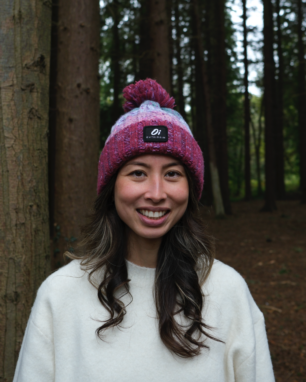Maroon and pastel knit pom beanie on head