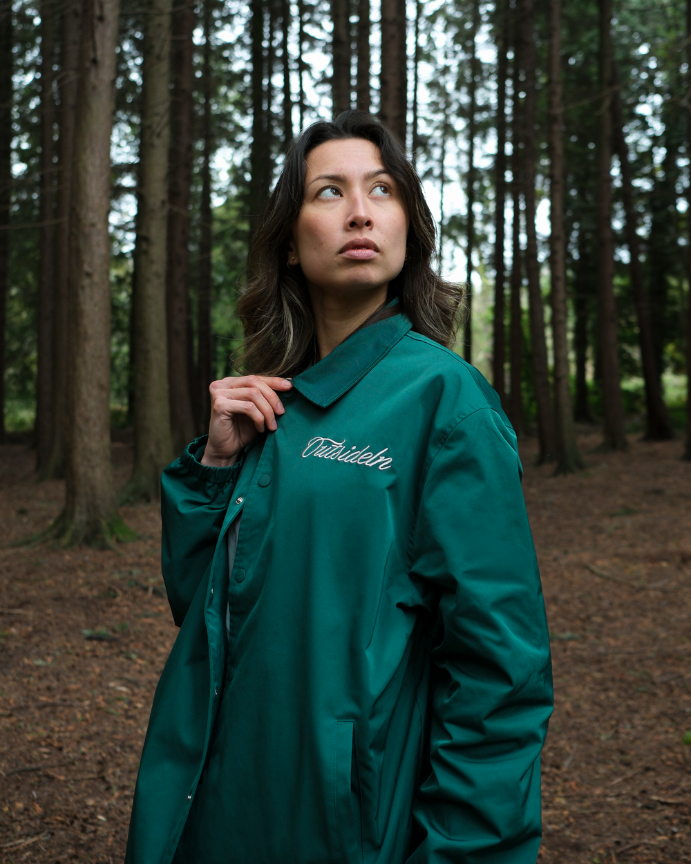 Model wearing Outside In Pine coach jacket, side view lifestyle photo