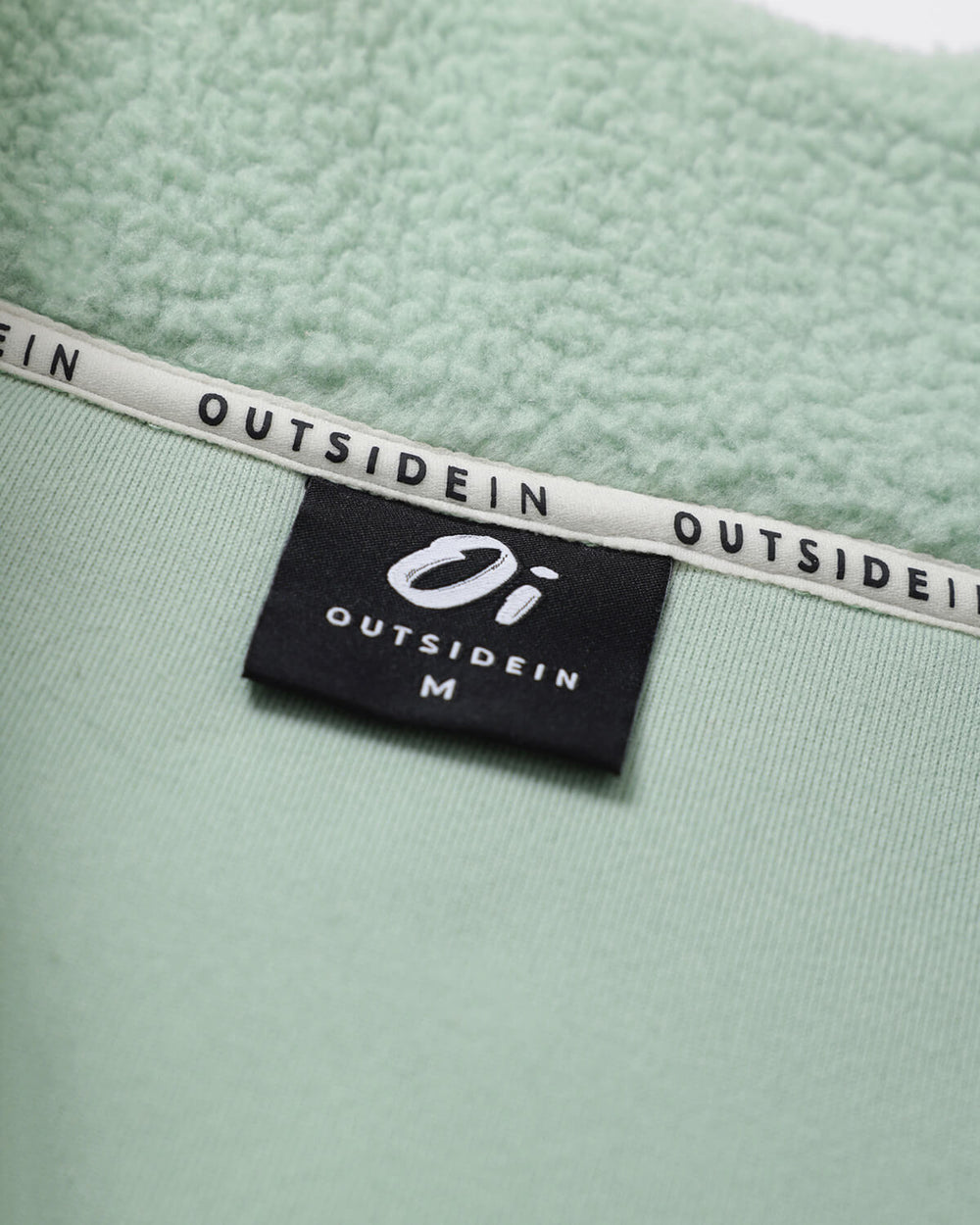 Woven brand label on sage green borg fleece