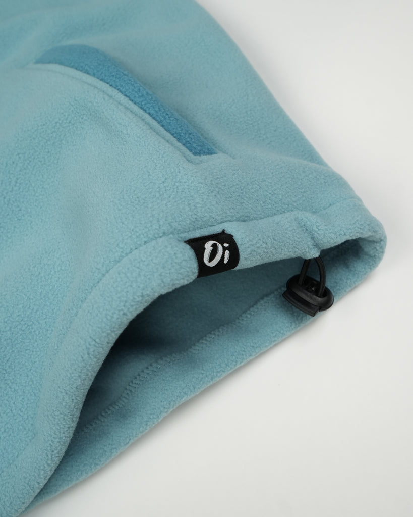 Unisex teal cream fleece with quarter zip, front pocket and toggle detail